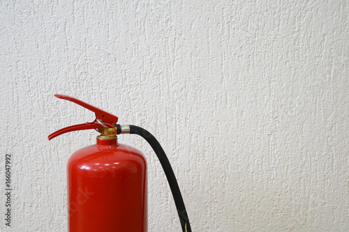 Red fire extinguiser on white background.