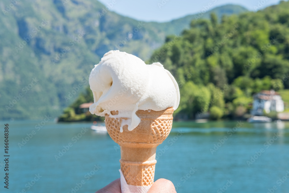 Hand holding cone of Gelato, Italian icecream with blur background of
