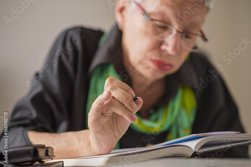 Canvastavla Senior old woman writing down letters on a piece of paper, recording a journal o