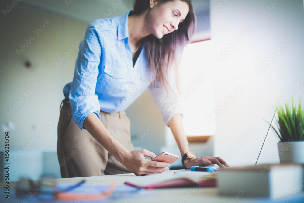 Beautiful young business woman sitting at office desk and talking on cell phone. Business woman Beautiful young business woman sitting at office desk and talking on cell phone. Business woman