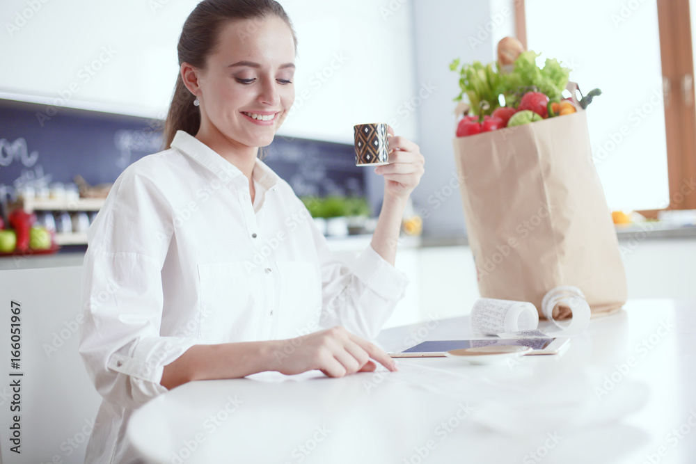 Young woman planning expenses and paying bills on her kitchen. Young woman planning expenses and paying bills on her kitchen.