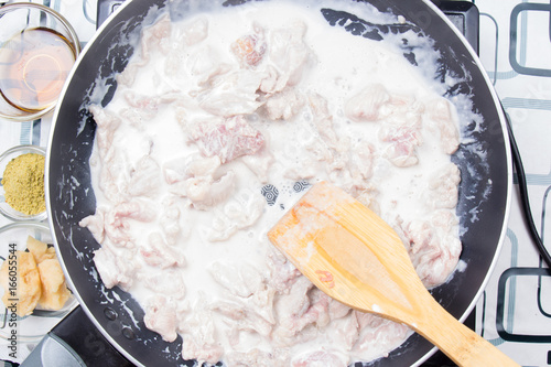 Chef stiring slice of beef with coconut milk photo