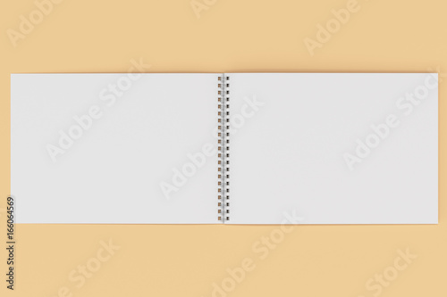 Open blank white notebook with metal spiral bound on orange background