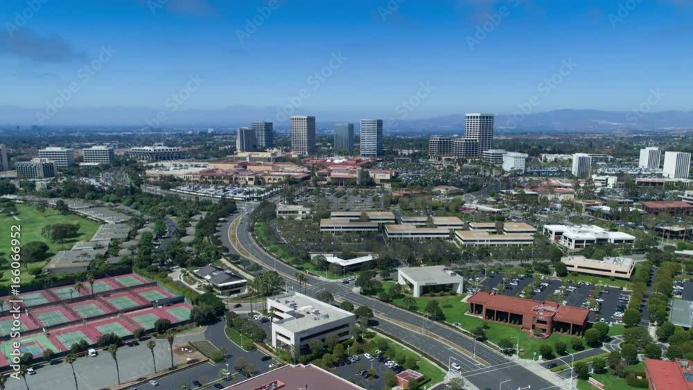 Urban aerial time lapse in motion (hyper lapse) from drone of shopping center city skyline in Newport Beach, California with high rise office buildings, traffic, clouds and mountains Urban aerial time lapse in motion (hyper lapse) from drone of shopping center city skyline in Newport Beach, California with high rise office buildings, traffic, clouds and mountains