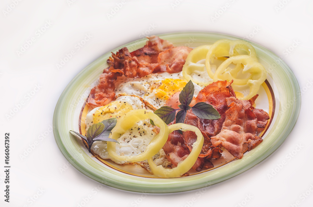 A hearty breakfast of scrambled eggs with bacon and green basil A hearty breakfast of scrambled eggs with bacon and green basil