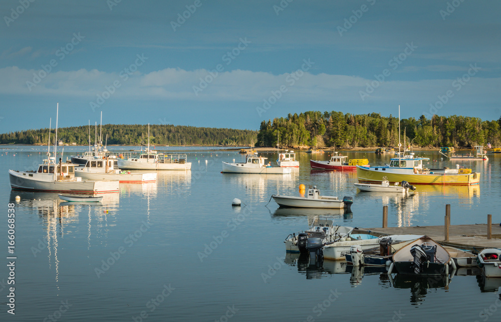 Obraz premium Lobster boats are moored in the harbor at dusk in Friendship, Maine