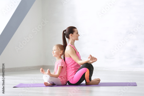 Mother and daughter doing exercise indoors © Africa Studio