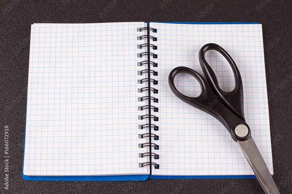 Top view on open blank notebook with cutter Top view on open blank notebook with cutter