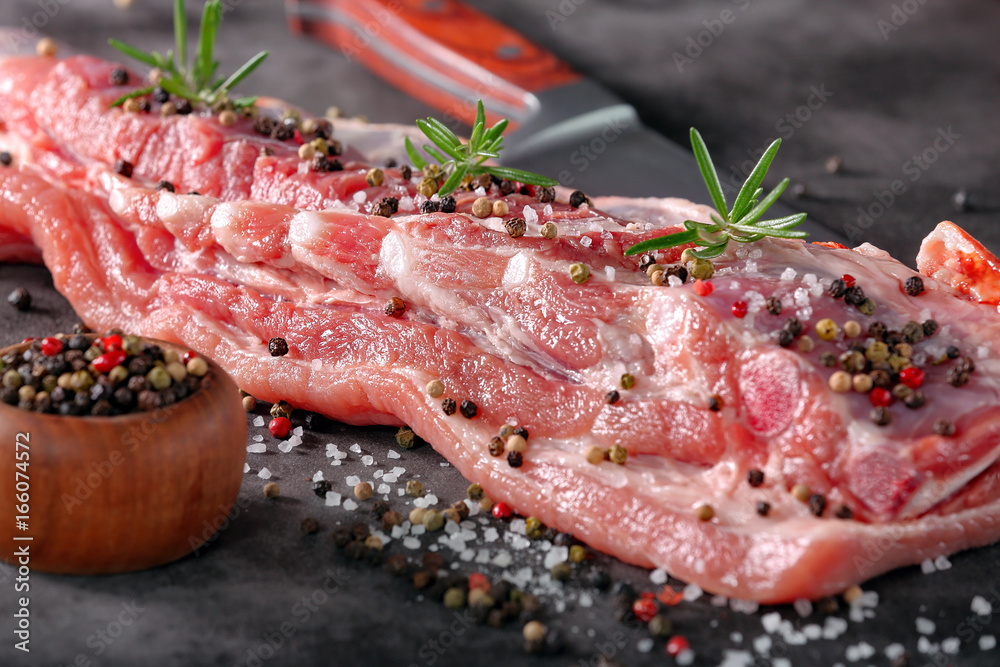 Raw ribs with spices on stone background Raw ribs with spices on stone background