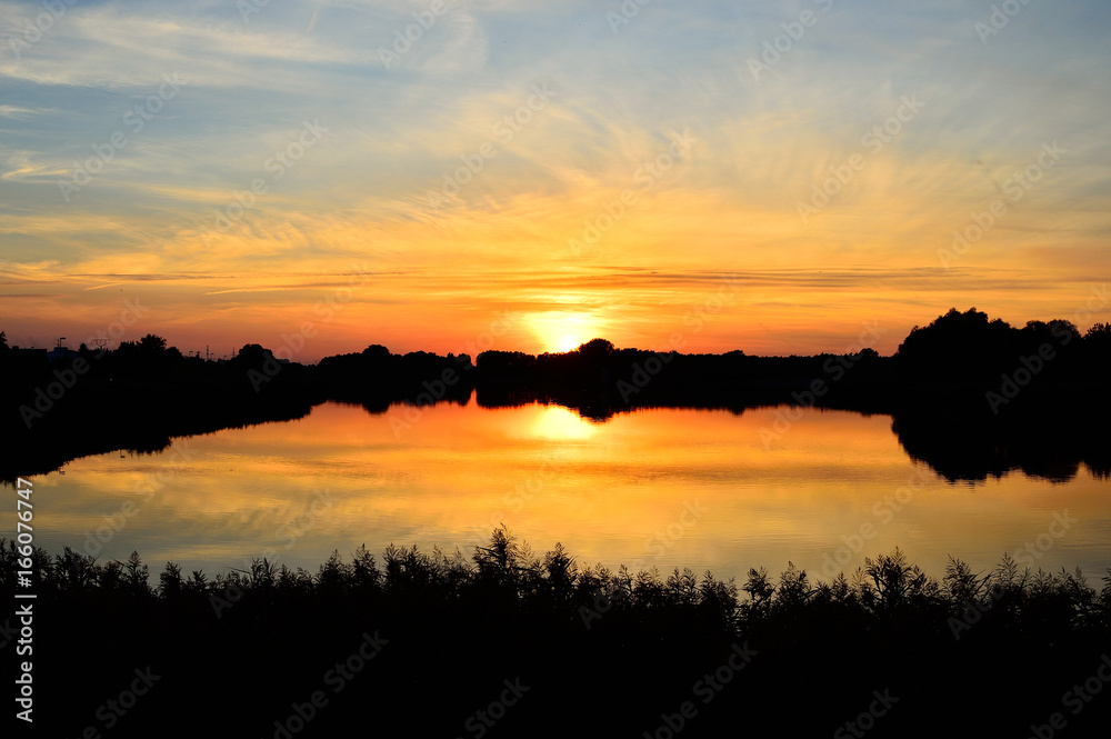 Zachód słońca nad jeziorem i odbicie w wodzie