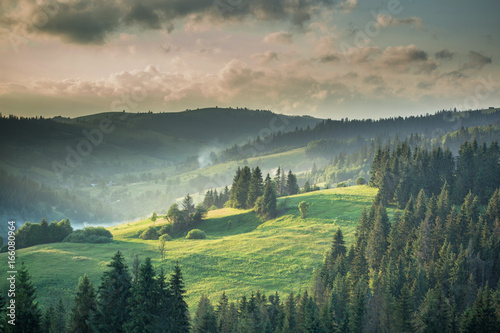 Tableau sur toile Mountain landscape and meadow illuminated by the sun