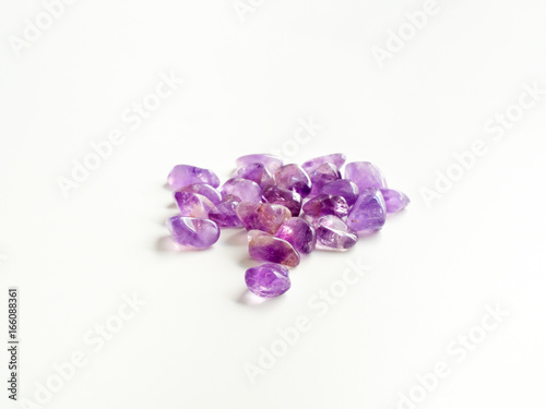 Tumbled Amethyst stones close up on table for crystal therapy treatments and reiki