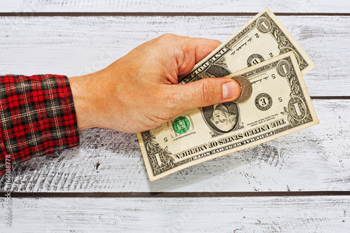 Wallpaper Mural Male hand in checkered shirt holding two US dollars Torontodigital.ca