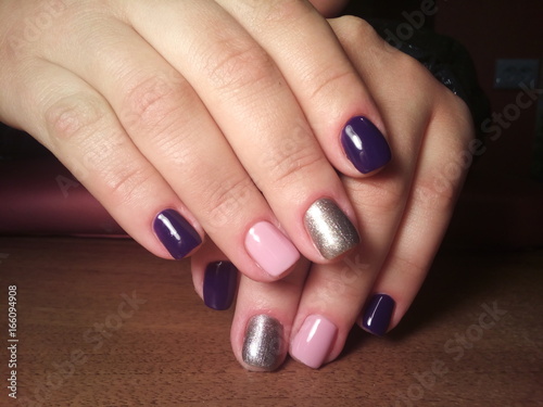 The manicurist excellently made her work a beautiful manicure with a polish gel on her hands and the client is happy