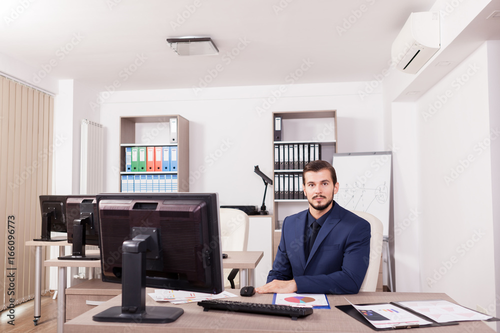 Young Businessman in suit working in his office. Business and corporate. Image of young succesful entrepreneur at his work place. Young Businessman in suit working in his office. Business and corporate. Image of young succesful entrepreneur at his work place.