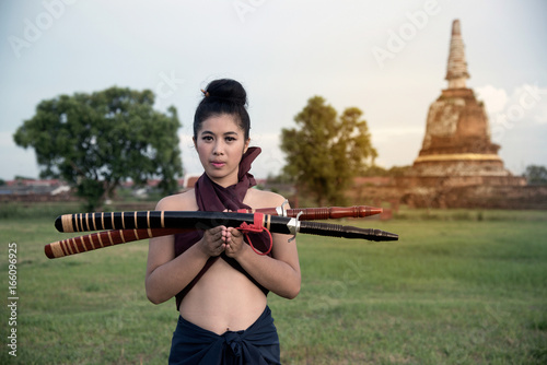 Pretty Asian woman posing in Thai ancient warriors at Wat Chang ancient abandoned temple in Ayutthaya Historical Park ,Thailand.