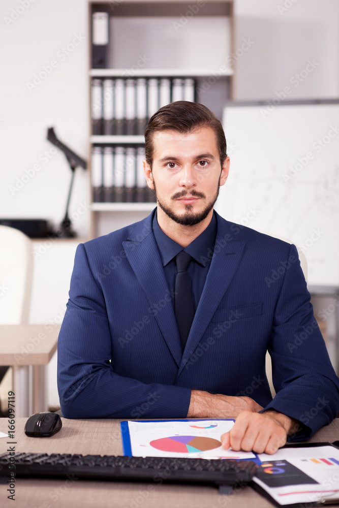 Professional Businessman in suit working in his office. Business and corporate. Image of young succesful entrepreneur at his work place. Professional Businessman in suit working in his office. Business and corporate. Image of young succesful entrepreneur at his work place.