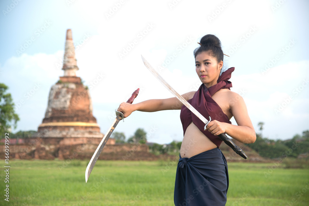 Pretty Asian woman posing in Thai ancient warriors at Wat Chang ancient abandoned temple in Ayutthaya Historical Park ,Thailand. Pretty Asian woman posing in Thai ancient warriors at Wat Chang ancient abandoned temple in Ayutthaya Historical Park ,Thailand.