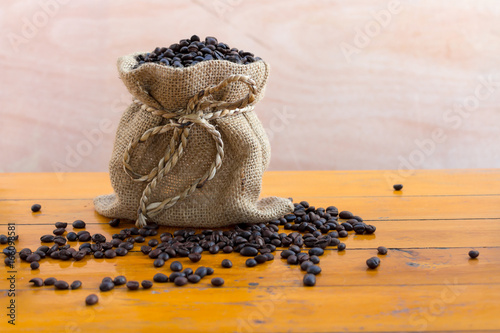 Coffee beans in sacks on wooden boards