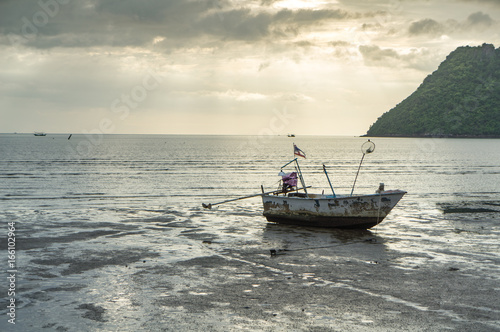fishing boat on the beach with sea and sunrise background © jumjie
