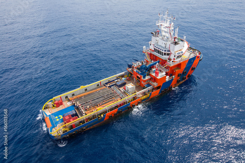 Fotografie, Obraz Crew boat and supply vessel at offshore oil and gas platform while loading piping, tubing for drilling operation of oil and gas reservoir