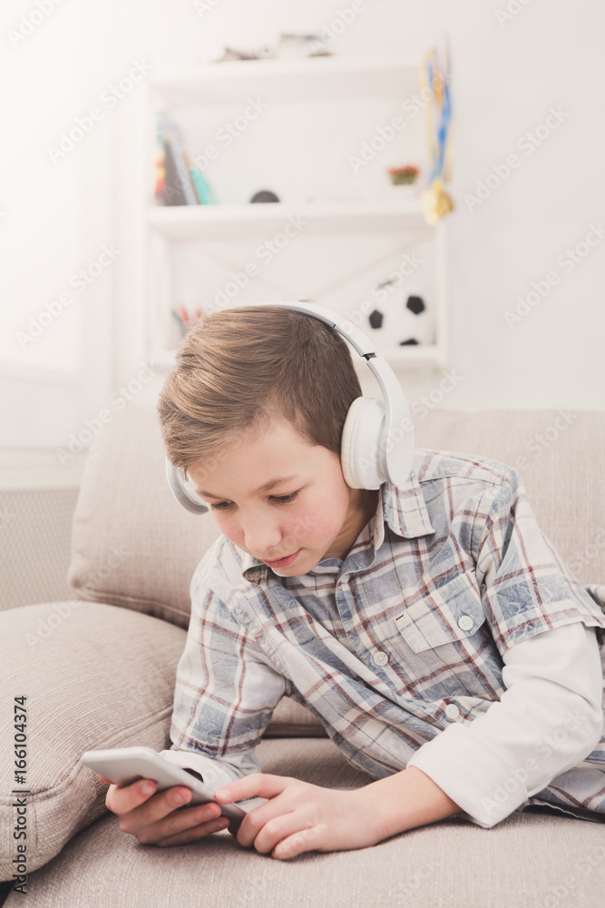 Teenager messaging online on smartphone in living room at home Teenager messaging online on smartphone in living room at home