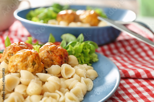 Plate with turkey meatballs and pasta on table, closeup