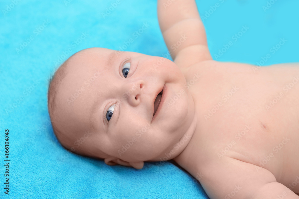 Beautiful baby lying on blue texture background Beautiful baby lying on blue texture background