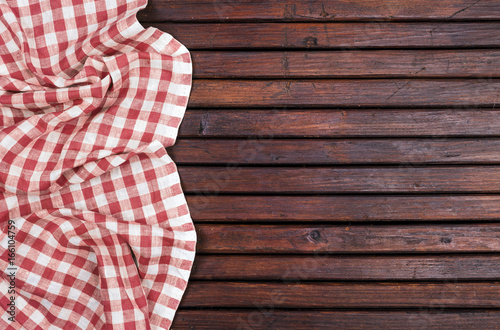 Red checkered tablecloth on dark wooden table with, top view with copy space