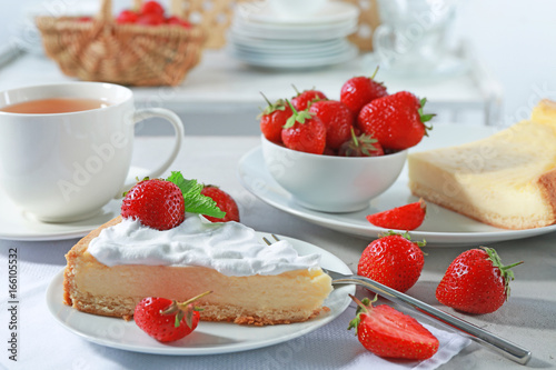 Piece of cake with cream and strawberries on plate