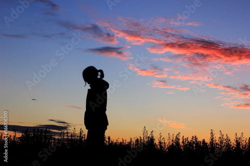 Sad girl on sunset background, silhouette.