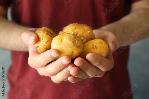 Man holding fresh young potatoes, closeup