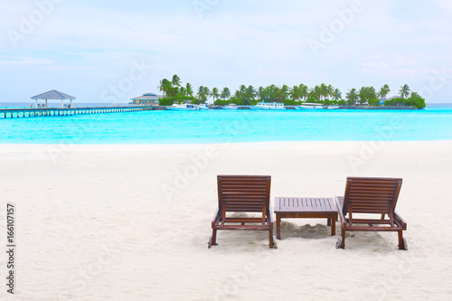 Fototapeta Naklejka Na Ścianę i Meble -  Wooden sun loungers on beach at sea resort