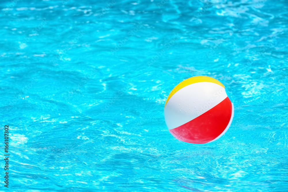 Colorful inflatable ball in blue swimming pool