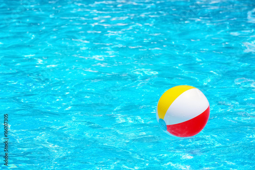 Colorful inflatable ball in blue swimming pool