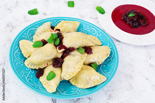 Delicious dumplings with cherry on white background