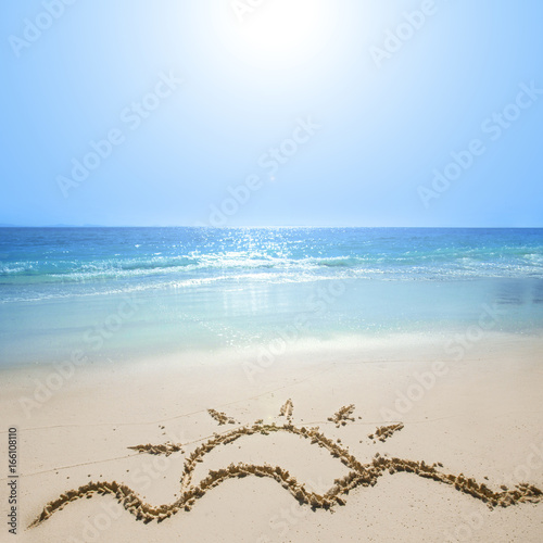 Drawing of sun on beach sand