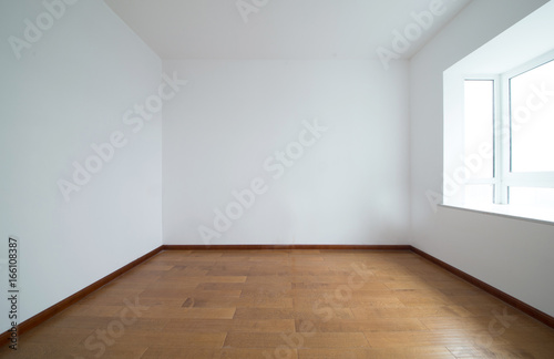 Light empty room with big white isolated window and wooden floor