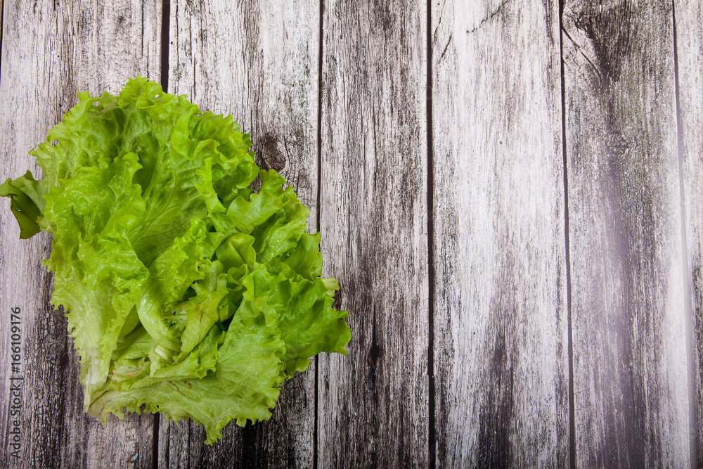 Lettuce leaves on a wooden background Lettuce leaves on a wooden background