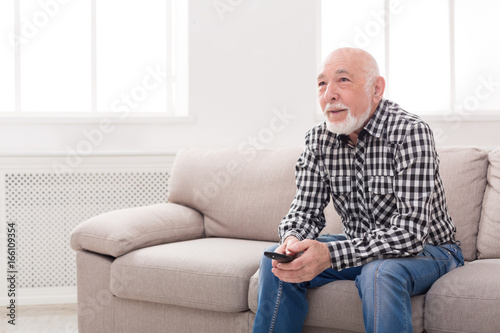 Calm senior man watching tv copy space © Prostock-studio