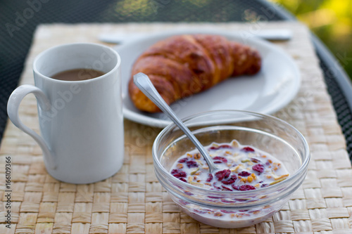 Frühstück mit Müsli und Croissant am Morgen
