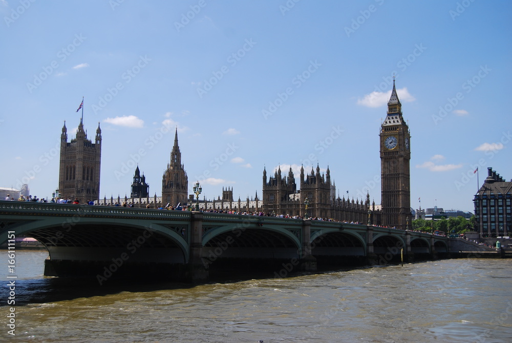London, United Kingdom - July 22, 2014: Typical summer day in London, tourists walking over Westminister bridge
