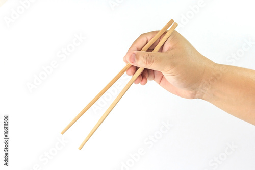 Hand holding disposable wooden chopsticks made of bamboo isolated on white background