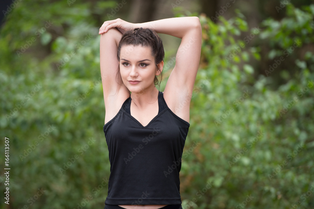 Sportswoman Stretching Arm in the Forest Sportswoman Stretching Arm in the Forest