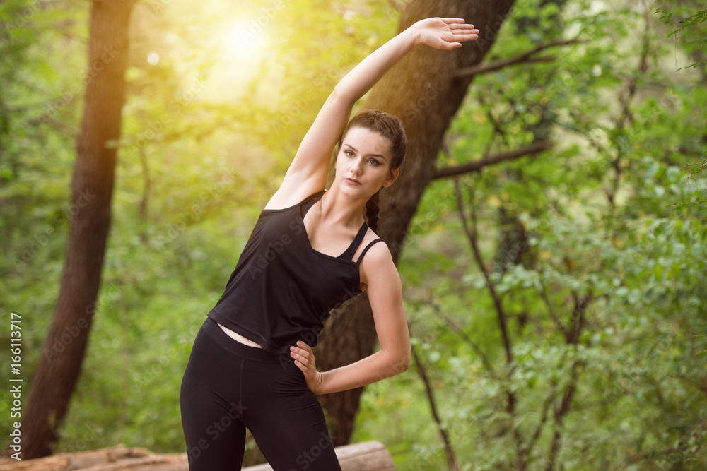 Fitness Woman Stretching In Wooded Forest Area Fitness Woman Stretching In Wooded Forest Area