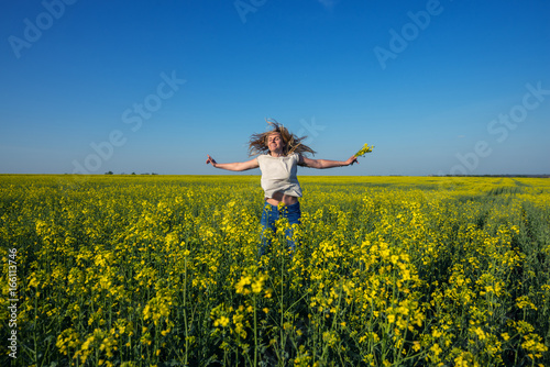 Happy young woman, with flying hair and open arms jumping