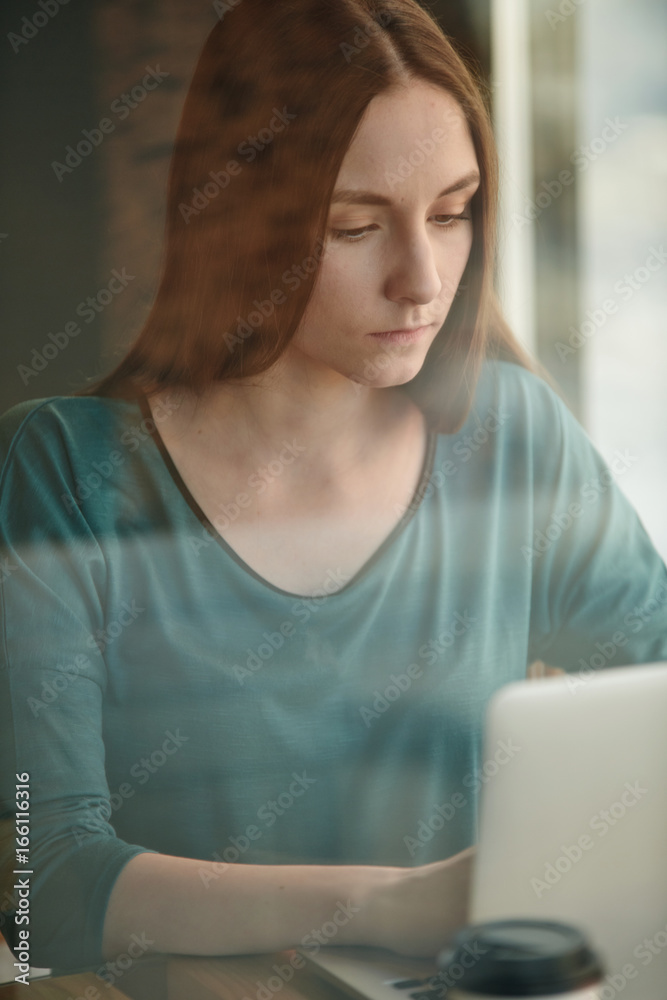 Portrait of young woman working on laptop at the cafe Portrait of young woman working on laptop at the cafe