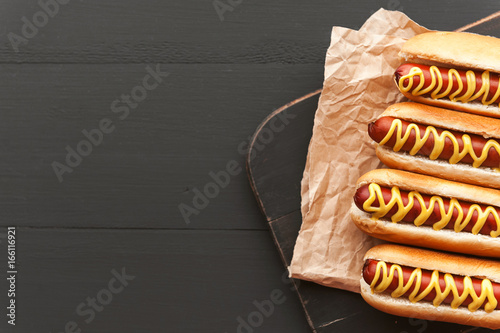 Barbecue Grilled Hot Dogs with  yellow American mustard, On a dark wooden background