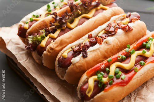 Barbecue Grilled Hot Dogs with yellow American mustard, On a dark wooden background