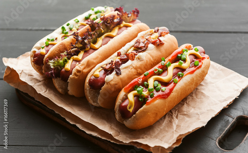 Photo Barbecue Grilled Hot Dogs with  yellow American mustard, On a dark wooden backgr